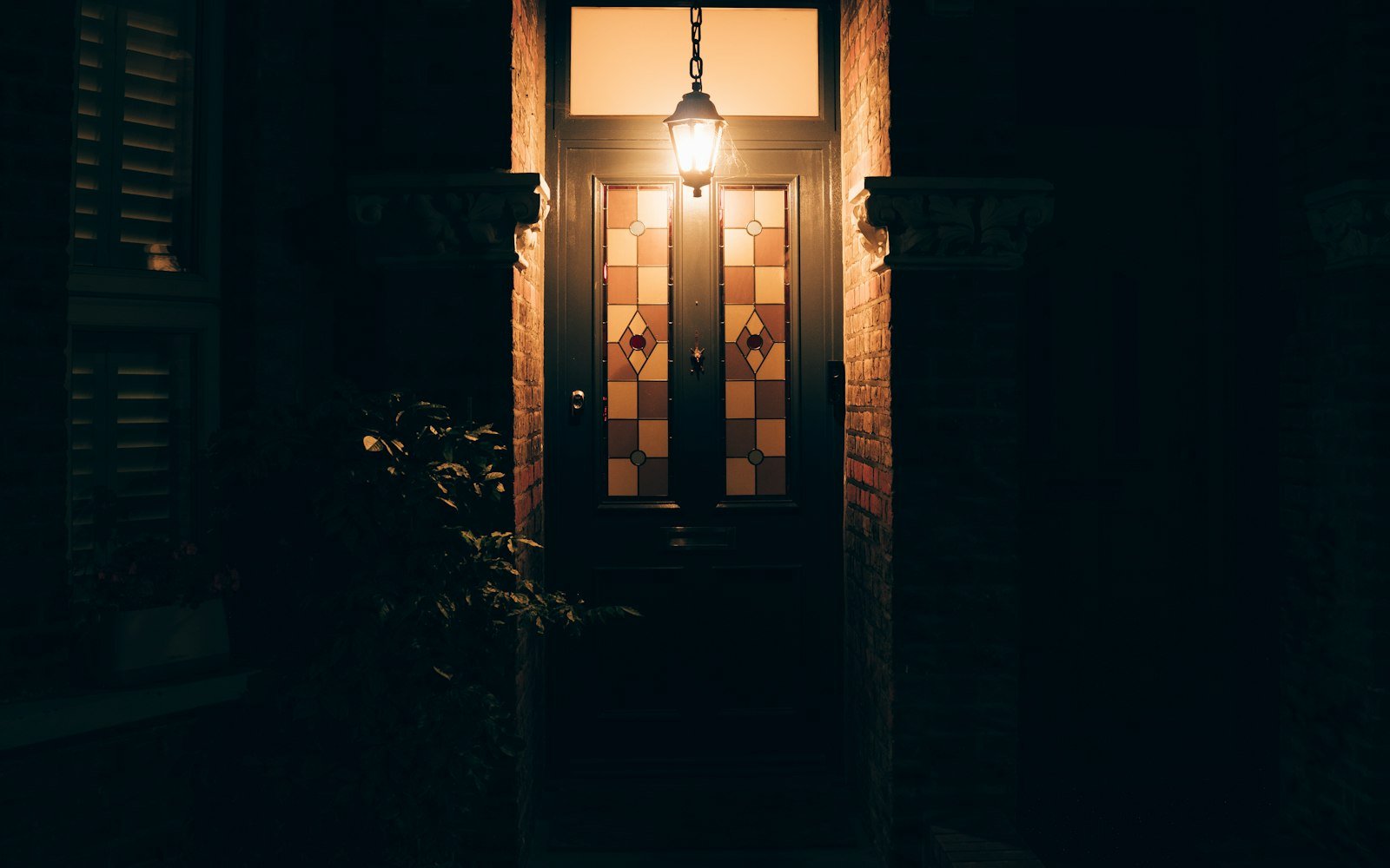 Front door of a house lit by a porch lamp at night