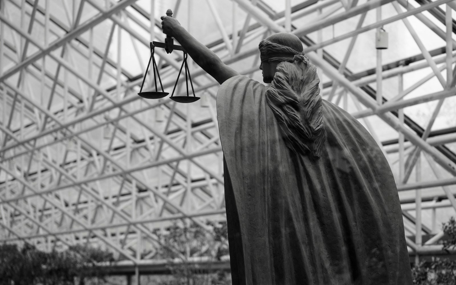 Statue of Justice holding scales, seen from behind