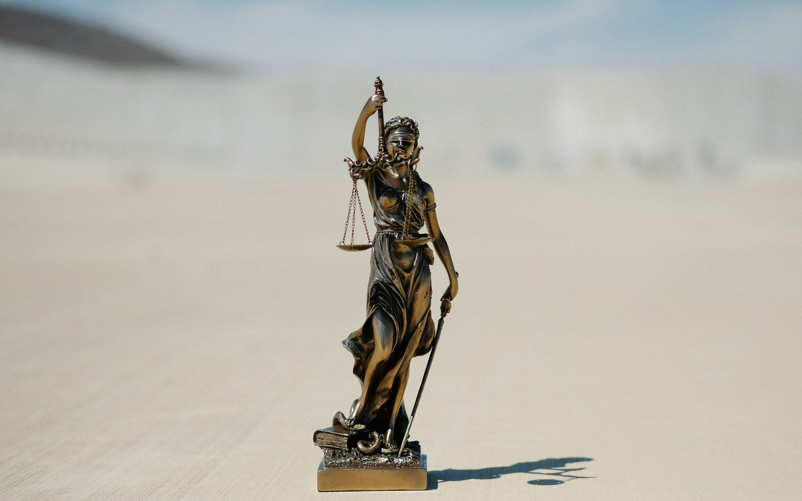 Small figure of Justice with scales on a desk