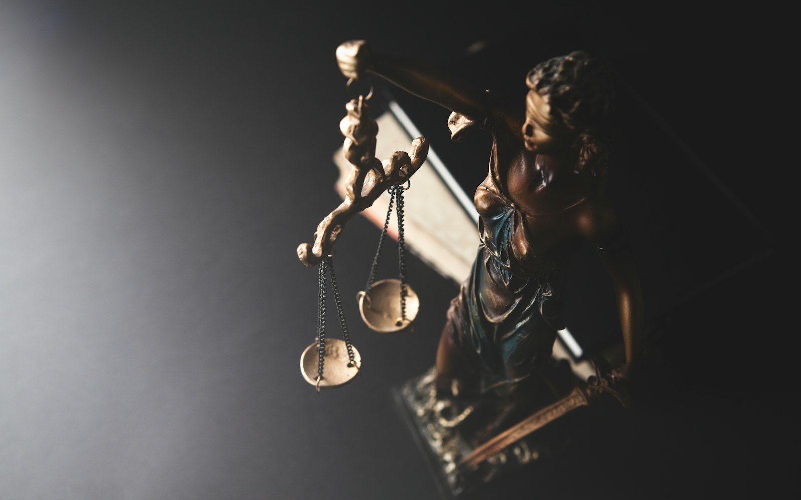Scales of justice figure in low light