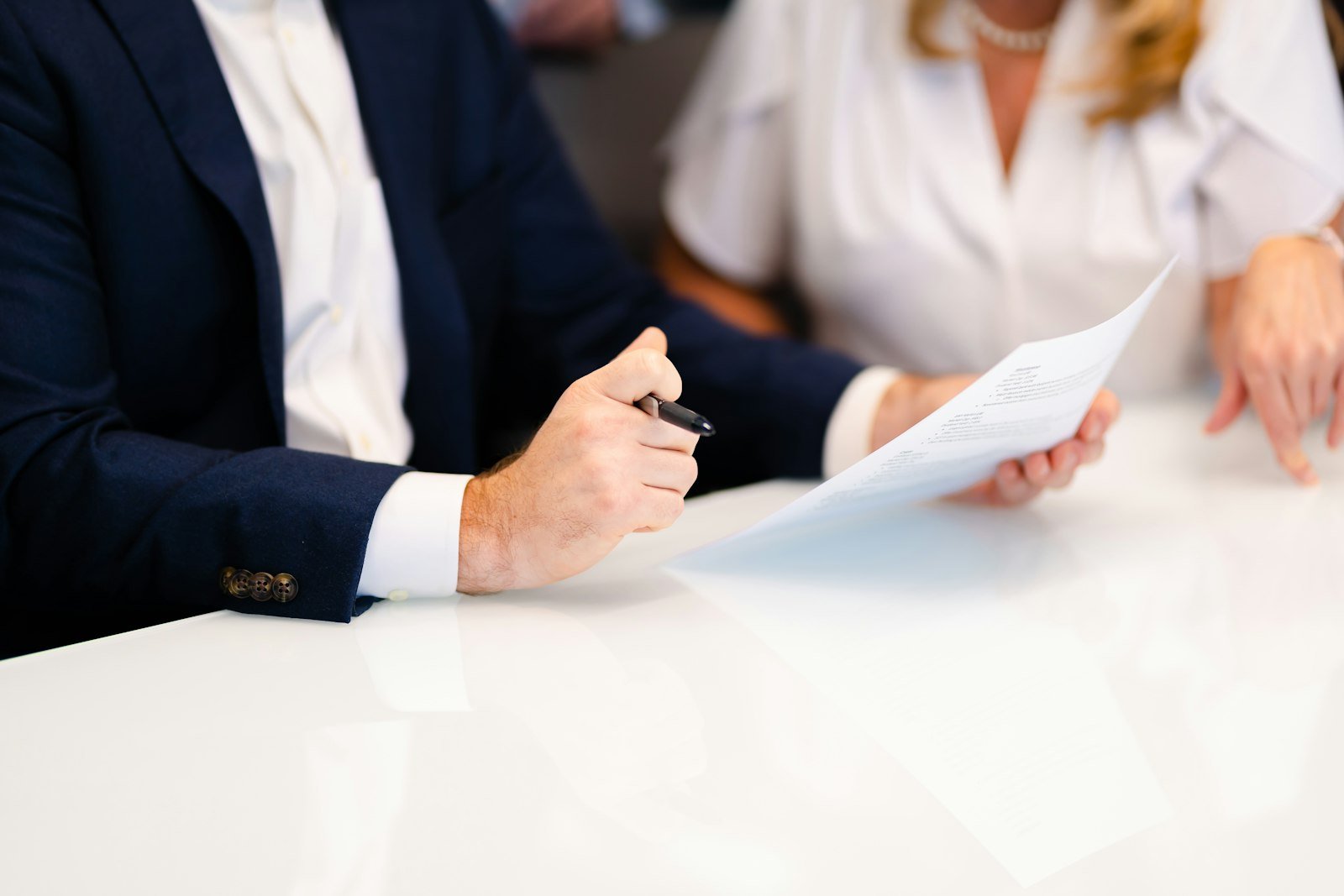 Two people at a table reviewing a document, faces not shown