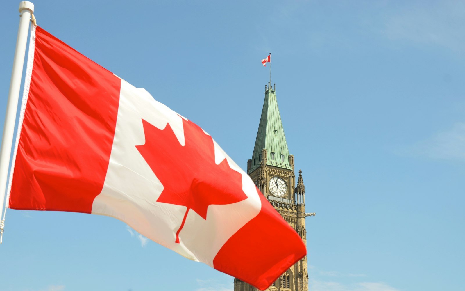 The Canadian flag flying beside the Peace Tower in Ottawa