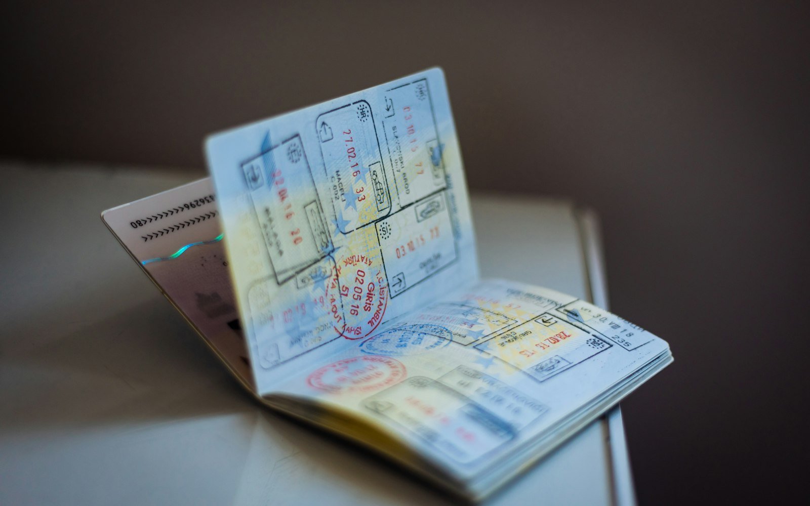 An open passport with entry stamps on a table