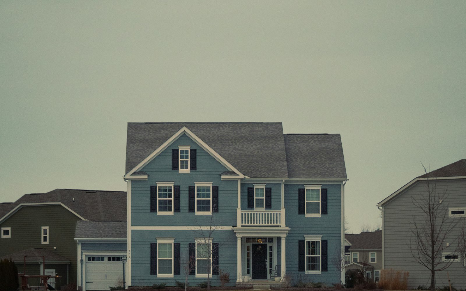 A blue two-storey house with dark shutters