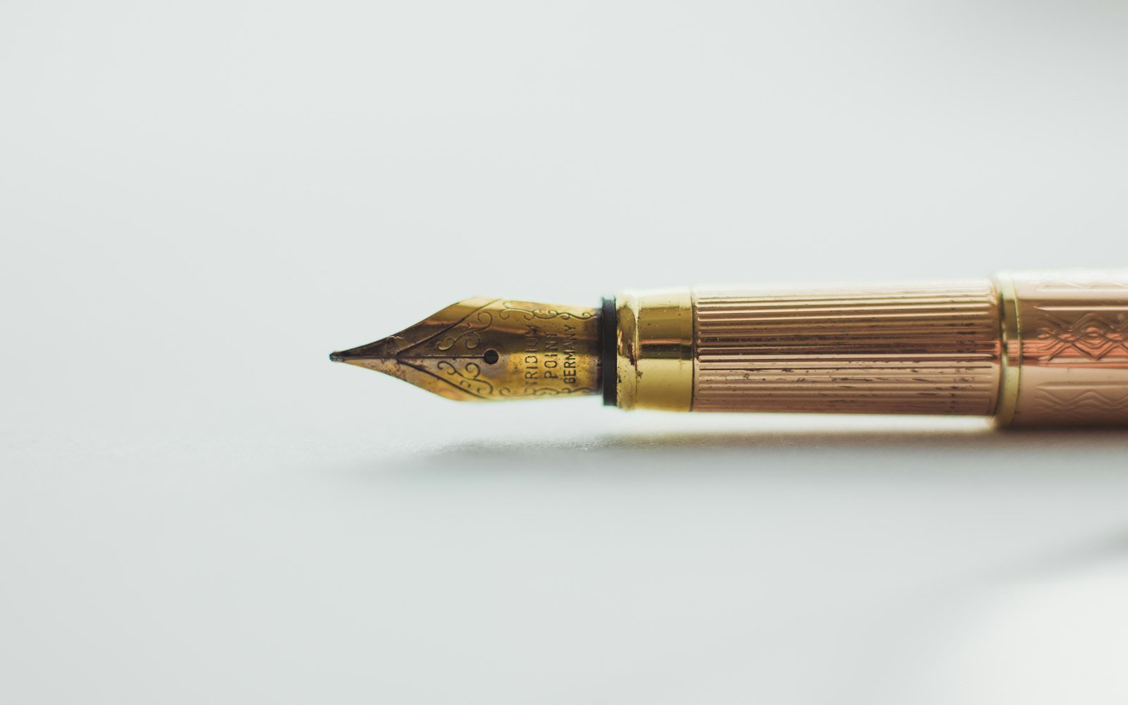 Gold fountain pen on a white surface